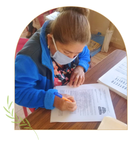 consentimiento1 Mujeres revisando y firmando documentos como parte de un proceso de consentimiento informado comunitario.